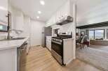 Discover this charming kitchen featuring sleek stainless steel appliances, including a modern gas range and a dishwasher.