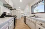 Discover this charming kitchen featuring a sleek stainless steel gas range and a modern range hood, perfect for culinary enthusiasts.