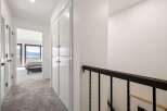 This hallway offers a glimpse into a serene bedroom with stunning lake views through large glass doors.