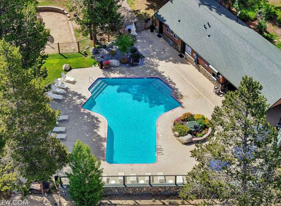 Enjoy a refreshing dip in this stunning geometric pool, surrounded by lush landscaping and ample lounge chairs for ultimate relaxation.