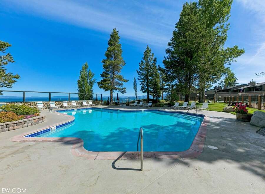 Enjoy a refreshing dip in this stunning swimming pool, complete with a sleek metal handrail for easy access.