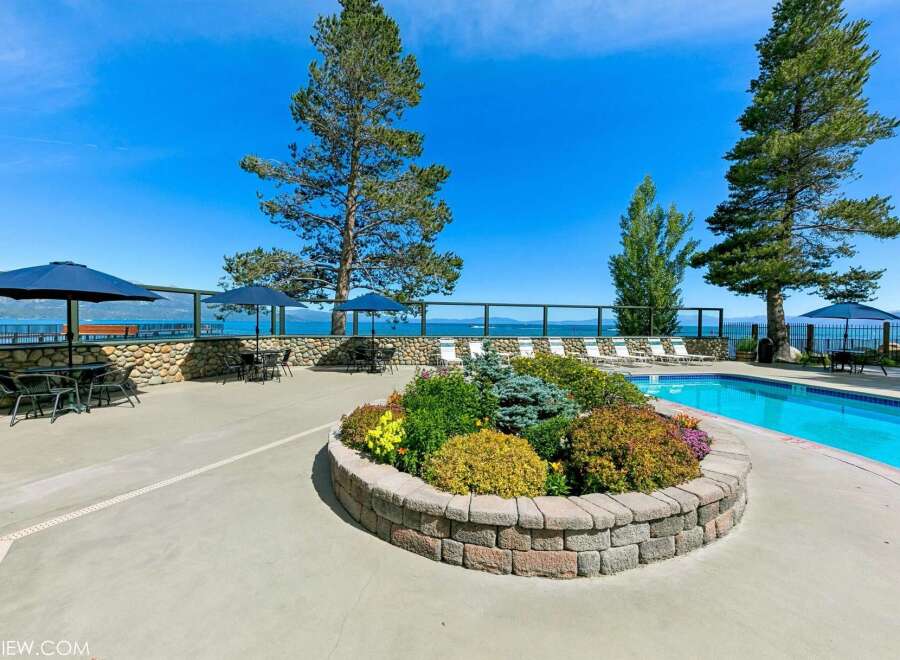 Enjoy breathtaking lake views from this stunning property featuring a sparkling swimming pool and ample outdoor seating.