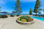 Enjoy breathtaking lake views from this stunning property featuring a sparkling swimming pool and ample outdoor seating.