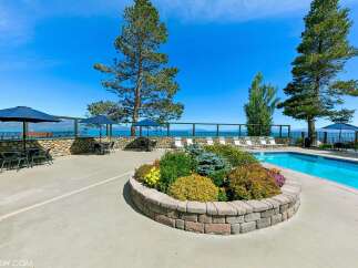 Enjoy breathtaking lake views from this stunning property featuring a sparkling swimming pool and ample outdoor seating.
