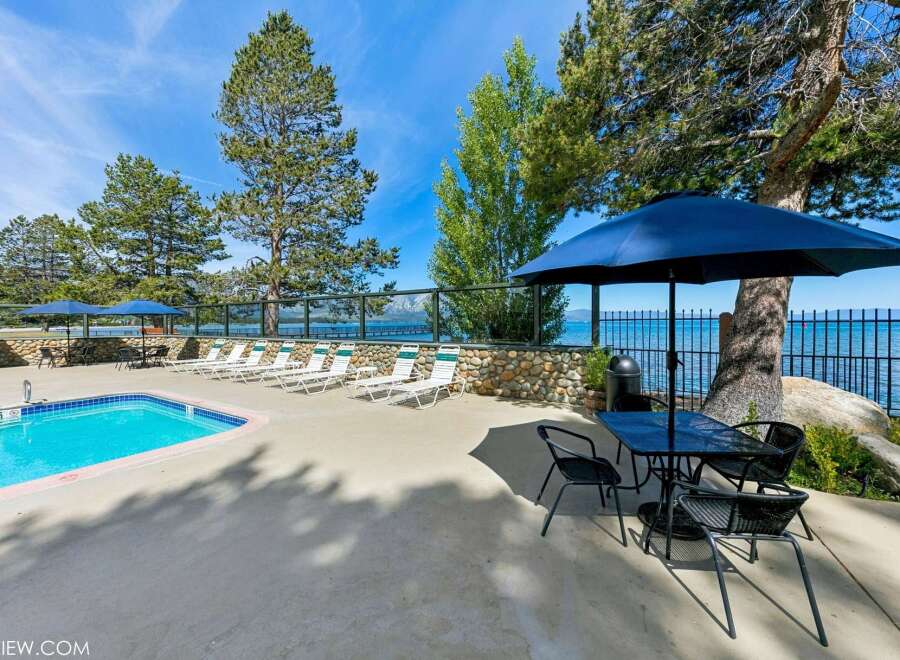 Enjoy a refreshing dip in the sparkling blue pool, surrounded by comfortable lounge chairs perfect for soaking up the sun.