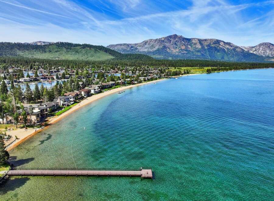 Experience luxury living with this stunning waterfront property offering direct access to a pristine sandy beach and crystal-clear turquoise waters.