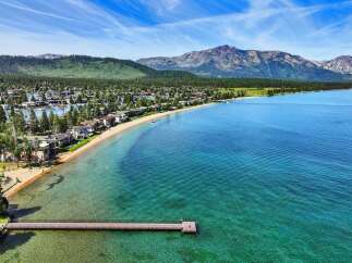 Experience luxury living with this stunning waterfront property offering direct access to a pristine sandy beach and crystal-clear turquoise waters.