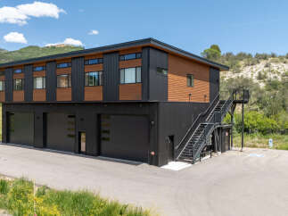 Discover modern living with this striking multi-level property, featuring a sleek black and wood exterior that complements the natural landscape.