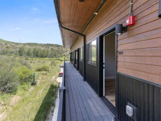 Experience modern living with this stunning property featuring a spacious balcony overlooking a serene natural landscape.