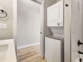 Discover modern convenience in this bathroom featuring a stacked washer and dryer unit, perfect for maximizing space.