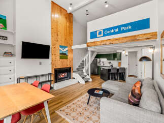 Experience modern living in this stylish apartment featuring a cozy fireplace and a well-equipped kitchen with bar seating.