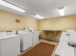 Discover the convenience of this well-maintained laundry room, featuring multiple Whirlpool washing machines for your use.