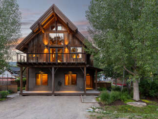 Experience rustic charm and modern comfort in this stunning wooden home, featuring a grand gable roof and expansive windows that capture natural light.
