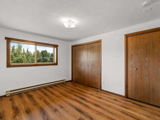 This spacious room features a large window offering a view of lush greenery, perfect for natural light.