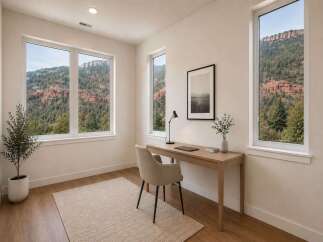 Experience breathtaking mountain views from this serene home office, featuring a minimalist desk and comfortable seating.