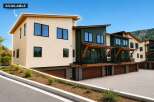 Discover modern living in this stunning townhome, featuring a sleek beige exterior and a contrasting dark green facade.