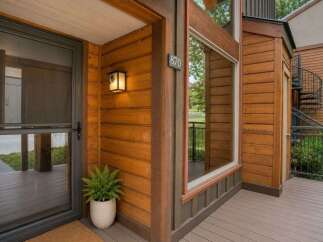 Experience rustic charm with this inviting entryway featuring warm wood siding and a welcoming porch.