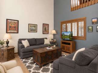 Experience rustic charm in this inviting living room, featuring a cozy dark gray sectional sofa and a unique wooden trunk coffee table.