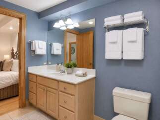This charming bathroom features a spacious vanity with ample storage and a bright, well-lit mirror.