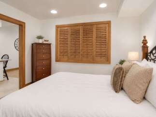 This charming bedroom features a comfortable bed with plush pillows and a rustic wooden dresser.
