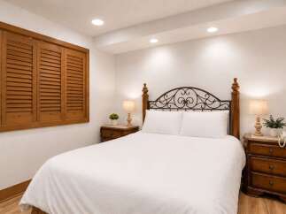 Experience comfort and style in this inviting bedroom, featuring a plush queen-size bed with a decorative metal headboard.