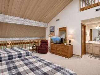 This charming bedroom features two cozy beds with plaid bedding, perfect for a restful night's sleep.