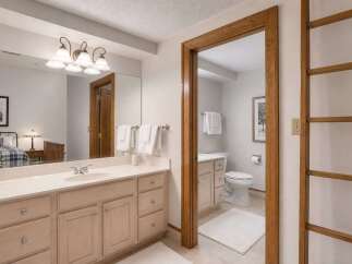This spacious bathroom features a double vanity with ample counter space and storage, perfect for any household.