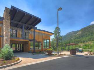 Discover this stunning modern lodge-style property, featuring a striking combination of natural stone and weathered metal siding.