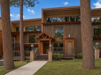 Experience modern mountain living in this stunning property featuring a striking wood-paneled exterior and expansive windows that invite natural light.