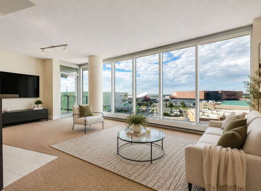 Experience breathtaking city views from this stunning living room, featuring expansive floor-to-ceiling windows that flood the space with natural light.