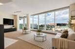 Experience breathtaking city views from this stunning living room, featuring expansive floor-to-ceiling windows that flood the space with natural light.
