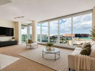 Experience breathtaking city views from this stunning living room, featuring expansive floor-to-ceiling windows that flood the space with natural light.
