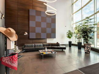 Step into a modern and inviting lobby featuring sleek black leather sofas and a stylish checkered accent wall.