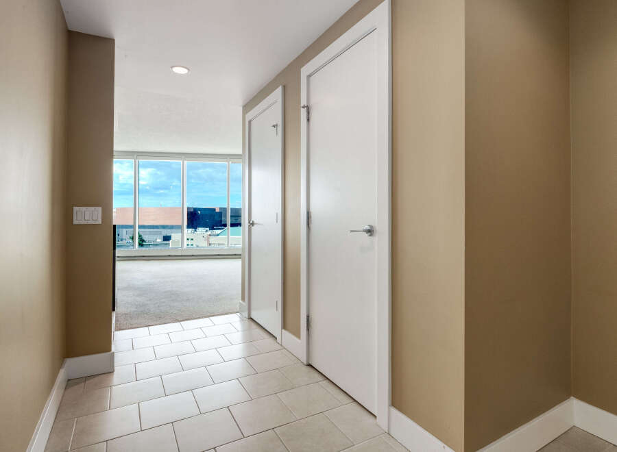 Step into this inviting hallway featuring a neutral color palette and sleek tile flooring.