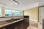Experience breathtaking city views from this modern kitchen, featuring a sleek double sink and ample counter space.