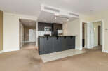 This modern condo features a sleek, dark wood kitchen with stainless steel appliances and a convenient breakfast bar.