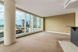 Experience breathtaking city views from this spacious living area, featuring expansive floor-to-ceiling windows that flood the room with natural light.