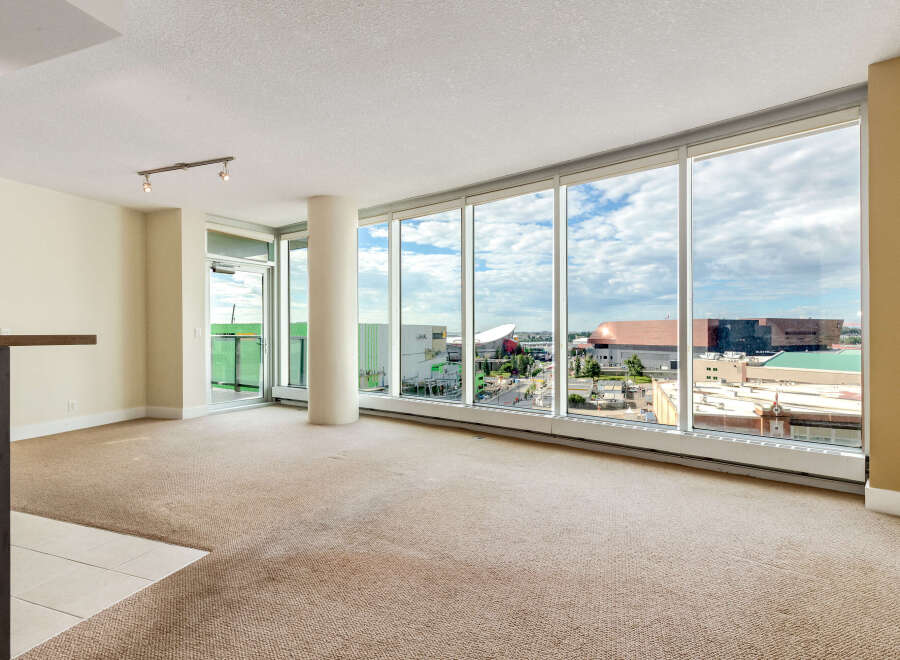 Experience breathtaking city views from this spacious living area, featuring expansive floor-to-ceiling windows that flood the room with natural light.