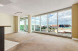Experience breathtaking city views from this spacious living area, featuring expansive floor-to-ceiling windows that flood the room with natural light.