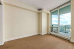 This empty room offers a blank canvas for your personal style, featuring neutral-toned walls and carpeting.