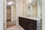 Discover modern comfort in this bathroom featuring a sleek vanity with dark wood cabinets and a white quartz countertop.