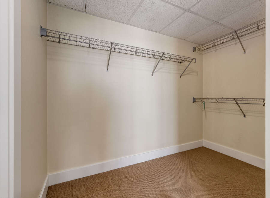 Discover ample storage in this spacious walk-in closet, featuring versatile wire shelving along multiple walls.