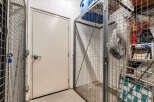 Secure your belongings in this spacious storage unit, featuring a sturdy metal cage with a padlock for added security.