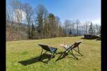 Enjoy breathtaking mountain views from this serene outdoor seating area, perfect for relaxing with a refreshing drink.