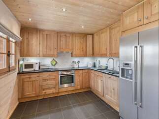 This charming kitchen features warm, natural wood cabinetry and a coordinating wooden ceiling, creating a cozy and inviting atmosphere.