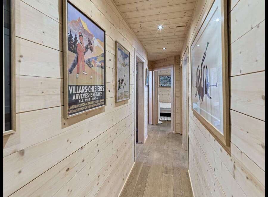 Step into this charming wooden hallway, adorned with vintage travel posters that evoke a sense of alpine adventure.