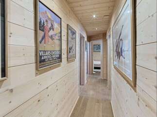 Step into this charming wooden hallway, adorned with vintage travel posters that evoke a sense of alpine adventure.