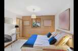 Experience cozy mountain living in this charming bedroom featuring a comfortable bed with striped linens and plush blue pillows.