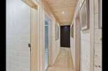 Step into this charming hallway featuring warm, natural wood paneling on the walls and ceiling, creating a cozy and inviting atmosphere.