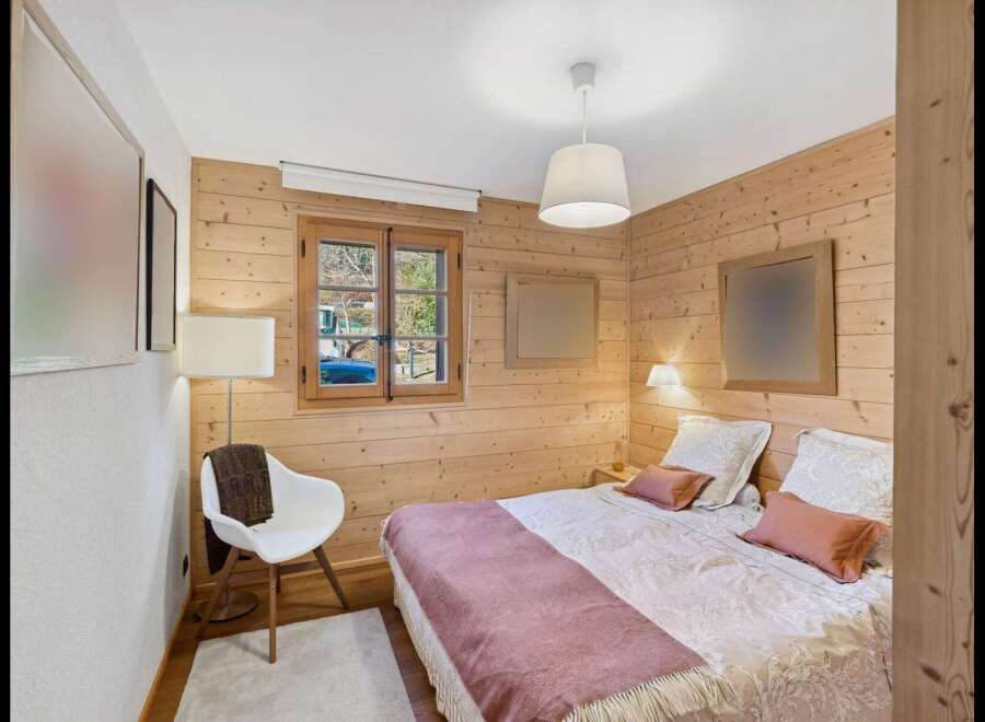 Experience rustic charm in this cozy bedroom featuring warm wood paneling throughout.